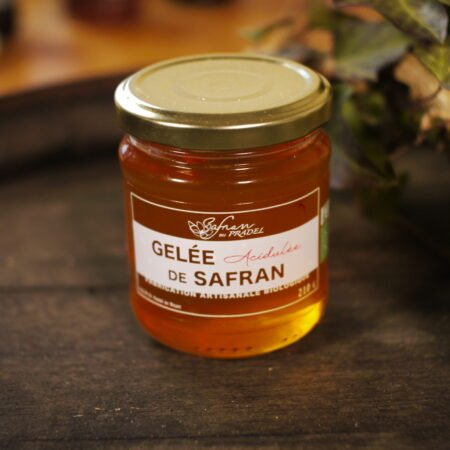 Présentation d'un pot de gelée acidulée de safran, sur le dessus d'un tonneau où un branche de lierre termine le décor